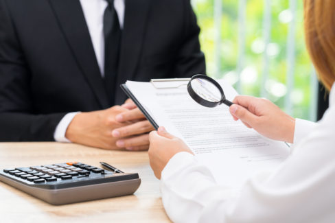 Woman inspects approved loan contract with bank seller