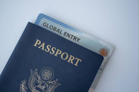 Global Entry card (Trusted traveller) covered of Passport of United states on white background.