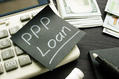 Memo sign PPP Loan Paycheck Protection Program on the black piece of paper.