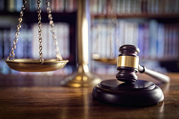 Scales of justice and a gavel in front of law books