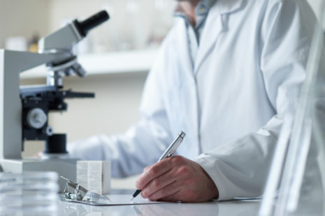 scientist conducting research with microscope selective focus