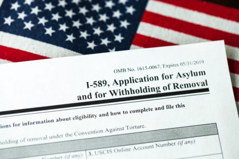 Application for asylum to USA concept with application form and USA flag