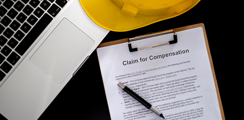 Laptop, hard hat and claim for compensation document