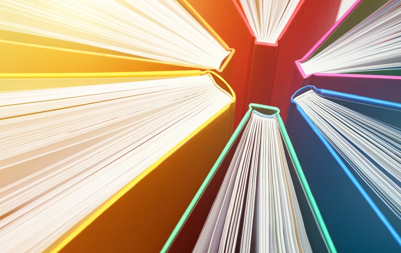 Books with a rainbow of cover colors arranged in a circle