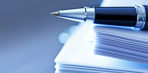 Pile of documents with pen on top