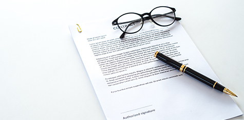 Eyeglasses and pen on top of contract document
